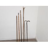 Vintage fishing sticks and fishing stand together with two walking sticks