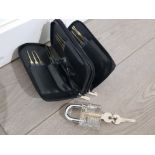 A set of professional lockpicks in zipped case with instructions and transparent practice padlock