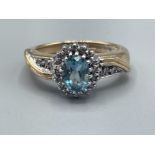 Ladies 9ct gold blue stone and diamond cluster ring, comprising of oval blue stone set in centre