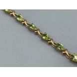 Ladies 14ct gold Peridot bracelet comprising of 16 pear shaped peridots set along bracelet with a