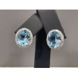 A pair of silver CZ and large blue topaz earrings