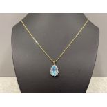 Ladies 9ct gold Blue Topaz pendant and chain. Featuring a pear shaped topaz and surrounded by a