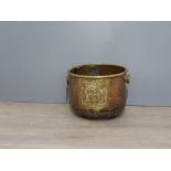 A copper and brass pot with lion head and ring handles