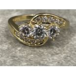 14ct gold 3 stone twist ring. Featuring 3 round CZ set in centre with a wave of 5 cz stones at top