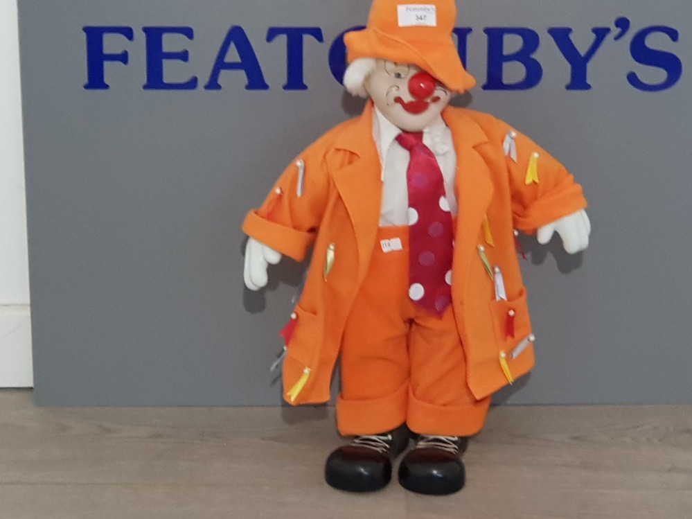 A PORCELAIN clown dressed in orange sute