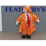 A PORCELAIN clown dressed in orange sute