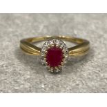 Ladies 9ct gold Ruby and Diamond cluster ring. Featuring a oval shaped Ruby surrounded by 14 round