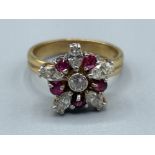 Ladies 18ct gold Ruby and Diamond cluster ring. Comprising of a Round brilliant cut diamond in