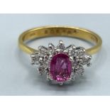 Ladies 18ct gold Ruby and Diamond cluster ring. Featuring a Oval shaped Ruby surrounded by 14