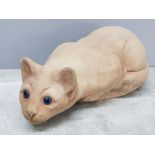 Vintage concrete pouncing cat ornament with striking blue eyes