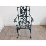 A green painted cast metal garden armchair.