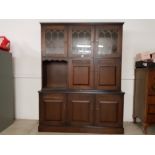 An oak effect sideboard with glazed cupboard doors 139cm wide.