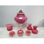 Seven pieces of cranberry glass to include a large footed bowl and cover 34cm high.