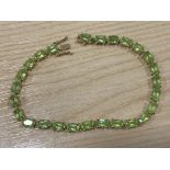 A 9ct yellow gold and peridot tennis bracelet, 9.2g gross, 19cm long including clasp.