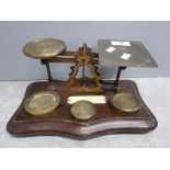 A set of vintage brass balance scales on mahogany base 27cm wide.