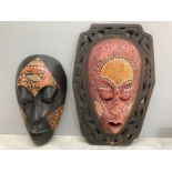 Two carved wooden tribal masks with painted decoration, largest 44cm high.