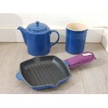 Small le creuset cast iron skillet, and a ceramic teapot and utensil holder by the same maker.