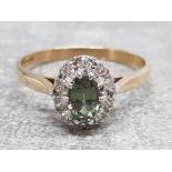 Ladies 9ct yellow gold, green and white stone cluster ring, comprising of a oval green stone set