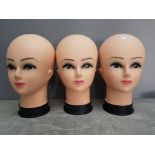 Three wig display heads.