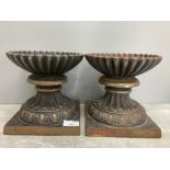 A pair of cast iron urns 18cm high.