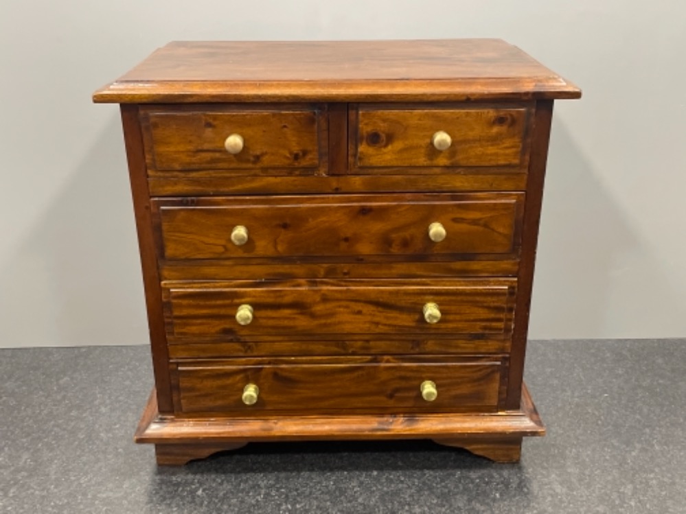 Apprentice miniature chest of 2 over 3 drawers in flame mahogany on bracket feet with brass handles.