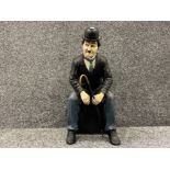 Large Charlie Chaplin figure of him sitting down with cane in his hand. 61cms