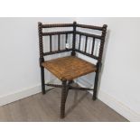 An early 20th century bobbin turned corner chair with reed seat.