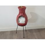 Pottery chiminea on metal stand in distinctive pink