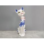 A 20th century delft style smiling cat wearing a pink ribbon 38.5cm high.