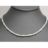 A 14k white gold and diamond link necklace comprising of 26 .03ct brilliant cut diamonds, 12 in star