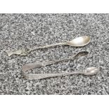 A pair of silver sugar tongs, sheffield, 15.9g, and a silver plated spoon.