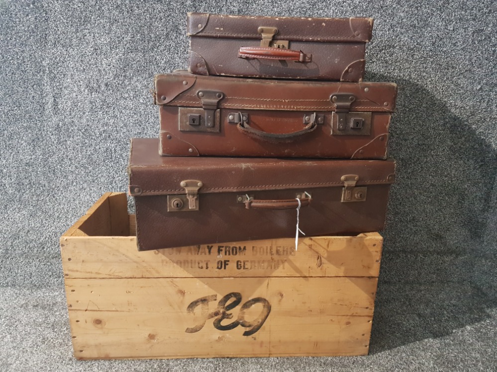 Three vintage brown suitcases and a german wooden crate.