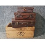 Three vintage brown suitcases and a german wooden crate.