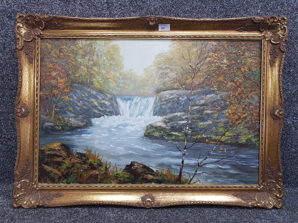 An oil painting by J Sudders, woodland river scene 49 x 74cm.