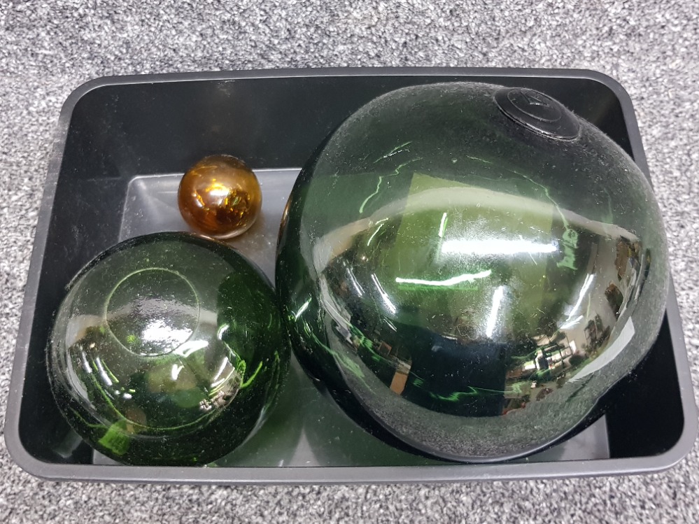 Three glass floats, largest with maker stamp.