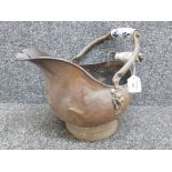 A copper and brass coal scuttle with ceramic handles.