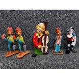 A ceramic clown figure playing the double base 24cm high, and four resin clowns