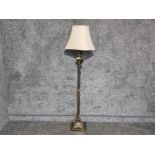 A lacquered metal and marble standard lamp with cream shade.