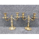 A pair of heavy ornate brass 2 way candlesticks with a leaf design