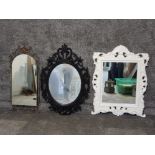 A metal work wall mirror and two other modern mirrors in black and white frames.
