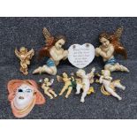 A pair of painted wooden cherubs, other cherubs and an art deco style ceramic wall plaque in the