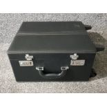A black leatherette suitcase on wheels possibly for a make up artist, with locks.