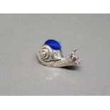 A silver pincushion in the form of a snail set with ruby eyes 5.58g gross