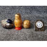 An early 20th century travelling clock in plated frame, a Russian doll and two other ornaments.