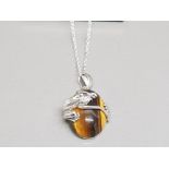 A silver necklace set with tigers eye pendant mounted by a silver frog 11.98g gross