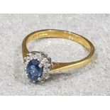 Ladies 18ct yellow gold blue stone + diamond cluster ring . Comprising of a oval blue stone in the