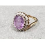 Ladies 9ct yellow gold amethyst + cubic zirconia cluster ring comprising of a oval amethyst set in