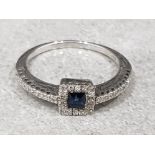 Ladies 18ct whitegold sapphire + diamond ring, comprising of a princess cut blue sapphire in the