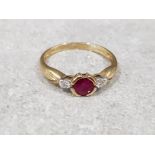 Ladies 9ct yellow gold ruby + diamond 3 stone ring, comprising of a round ruby set in the centre
