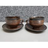 A good pair of cups and saucers by Gwyn Hanssen Pigott in rich Tenmoku glaze with impressed mark